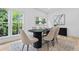 Dining room features wood floors, a modern table, and natural light from large windows at 1749 Patriots Nw Way, Kennesaw, GA 30152
