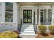Charming brick home entrance featuring black framed glass doors and manicured landscaping at 1749 Patriots Nw Way, Kennesaw, GA 30152