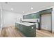 A chef's kitchen with custom green cabinets and a large island with sink at 1749 Patriots Nw Way, Kennesaw, GA 30152