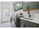 Well-organized laundry room featuring modern washer and dryer, custom cabinets, and a sink with quartz countertops at 1749 Patriots Nw Way, Kennesaw, GA 30152