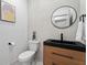 Modern powder room with stylish vessel sink, designer mirror, wood vanity, and a contrasting black countertop at 1749 Patriots Nw Way, Kennesaw, GA 30152