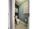 Small powder room with gray and teal walls and updated finishes at 2030 Hydrangea Ln, Austell, GA 30106