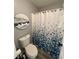 Compact bathroom featuring a white toilet, a patterned shower curtain, and decorative wall art at 2030 Hydrangea Ln, Austell, GA 30106