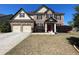 A charming two-story brick home with a red front door and manicured landscaping at 2030 Hydrangea Ln, Austell, GA 30106