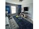 Modern living room with gray sofa, a blue rug, and mounted TV for entertainment at 2030 Hydrangea Ln, Austell, GA 30106