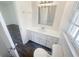 Bright bathroom features a large mirror, white vanity, and modern fixtures, as well as a window with outside light at 294 Farm Ridge Ne Dr, Woodstock, GA 30188