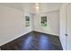 An updated bedroom with dark vinyl floors with white trim and white walls and natural light from multiple windows at 294 Farm Ridge Ne Dr, Woodstock, GA 30188