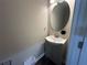 Modern bathroom featuring a vanity with a single sink and a round mirror at 3407 Hidden Stream Ct, Stockbridge, GA 30281