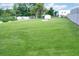 Expansive backyard showcasing a lush lawn, storage sheds, and mature trees creating a private retreat at 1083 Grace Dr, Forest Park, GA 30297