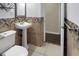 Bathroom featuring modern toilet and pedestal sink, and brown decorative tile at 1083 Grace Dr, Forest Park, GA 30297