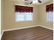 Bedroom features laminate flooring, natural light, and decorative red valances at 1083 Grace Dr, Forest Park, GA 30297