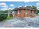 Rear of brick home with a spacious driveway, manicured lawn, and small wooden decks at 1083 Grace Dr, Forest Park, GA 30297
