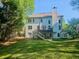 Expansive backyard with a large lawn, a deck, and a covered patio for outdoor enjoyment, surrounded by trees at 2870 Willow Wisp Way, Cumming, GA 30040