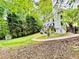 Spacious backyard with a white house, deck, shed, green lawn, and bordering trees at 2870 Willow Wisp Way, Cumming, GA 30040