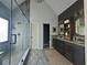 Modern bathroom with glass shower, double vanity, stylish lighting, and gray tile flooring at 2870 Willow Wisp Way, Cumming, GA 30040