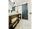 Stylish bathroom with double vanity, modern fixtures, marble floors, and a unique sliding barn door at 2870 Willow Wisp Way, Cumming, GA 30040