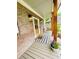 Inviting front porch with brick columns, a wooden door with wreath, a welcome mat, and potted flowers at 2870 Willow Wisp Way, Cumming, GA 30040