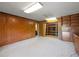 Basement area featuring built-in shelving, wood paneled walls, and neutral carpet at 3844 Lake Se Dr, Smyrna, GA 30082