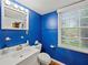 Bright bathroom with blue walls, a white vanity, and natural lighting at 3844 Lake Se Dr, Smyrna, GA 30082