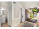 Bright entryway leading to a bathroom with the front door open to brick steps, and green foliage outside at 5250 Chemin De Vie, Atlanta, GA 30342