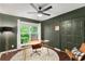The office is illuminated by light coming from a window, sconce, and overhead fan with light at 5250 Chemin De Vie, Atlanta, GA 30342