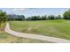 Expansive green space with a winding pathway offers a serene and inviting area for recreation and relaxation at 6103 Menlow Ct, Cumming, GA 30041