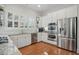 Eat-in kitchen with white cabinets, stainless appliances, granite countertops, and hardwood floors at 104 Glentown Way, Sandy Springs, GA 30328
