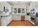 Bright eat-in kitchen featuring white cabinets, stainless steel appliances, and hardwood floors at 104 Glentown Way, Sandy Springs, GA 30328