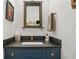 Stylish powder room with a dark vanity, unique mirror, and patterned wallpaper at 104 Glentown Way, Sandy Springs, GA 30328