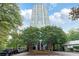 High-rise condominium building surrounded by lush greenery on a sunny day, with parking in front at 2870 Pharr Court South Nw # 1704, Atlanta, GA 30305