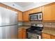 Well-equipped kitchen features stainless steel appliances and warm wood cabinetry with granite countertops at 2870 Pharr Court South Nw # 1704, Atlanta, GA 30305