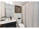 Modern bathroom featuring a black vanity, framed art, and a striped shower curtain at 371 Northaven Ave, Suwanee, GA 30024