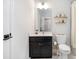 Well-lit bathroom featuring a black vanity, circular mirror, and gold fixtures at 371 Northaven Ave, Suwanee, GA 30024