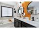 Bright bathroom features dual vanity, round mirrors, gold hardware, and a soaking tub at 371 Northaven Ave, Suwanee, GA 30024