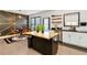 Modern kitchen island with seating and stainless appliances adjacent to a geometric accent wall at 371 Northaven Ave, Suwanee, GA 30024