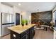 Modern kitchen island with seating adjoins a dining area with a geometric accent wall at 371 Northaven Ave, Suwanee, GA 30024