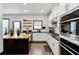 Modern kitchen features white cabinets, black countertops, a gold accented island, and stainless steel appliances at 371 Northaven Ave, Suwanee, GA 30024