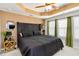 This bedroom features a large upholstered headboard, decorative lighting, and an attractive tray ceiling at 371 Northaven Ave, Suwanee, GA 30024