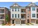 Beautiful townhouse featuring a white brick facade, two balconies, and an attached garage at 427 Burton Dr, Alpharetta, GA 30009