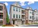 Charming townhouses showcasing brick and white facades, complemented by individual garages at 427 Burton Dr, Alpharetta, GA 30009