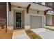 Close up of a townhouse front door and garage, showcasing the brickwork and carriage lights at 427 Burton Dr, Alpharetta, GA 30009