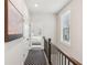 Upstairs hallway featuring wood floors, an art piece, and a view of a bedroom at the end at 427 Burton Dr, Alpharetta, GA 30009