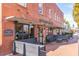 Outdoor seating in front of a classic brick building with large windows, creating an inviting and lively atmosphere at 427 Burton Dr, Alpharetta, GA 30009