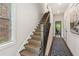 Carpeted staircase with dark wood trim and a patterned runner, illuminated by natural light at 427 Burton Dr, Alpharetta, GA 30009