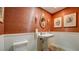 Stylish powder room featuring a pedestal sink, wainscoting, and unique wall texture at 470 Ansley Walk Ne Ter, Atlanta, GA 30309