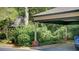 Attached carport next to a small gazebo surrounded by lush landscaping with a brick foundation at 470 Ansley Walk Ne Ter, Atlanta, GA 30309