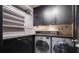 Well-organized laundry room with washer, dryer, shelving, and dark countertops at 470 Ansley Walk Ne Ter, Atlanta, GA 30309