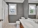 Full bathroom with double windows, a large vanity, and a decorative mirror at 635 Hickory Nobb, Sugar Hill, GA 30518