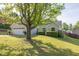 Landscaped front yard with mature tree, green grass, and a charming light green home at 635 Hickory Nobb, Sugar Hill, GA 30518