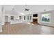 Open-concept living area boasts a brick fireplace, large windows, and flows seamlessly into the kitchen at 635 Hickory Nobb, Sugar Hill, GA 30518